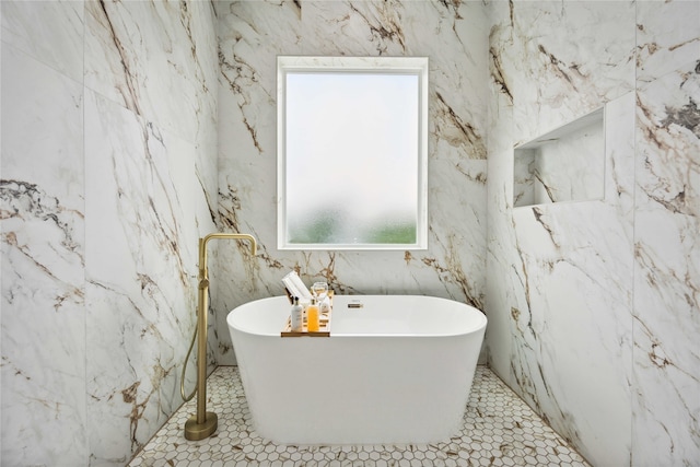 bathroom with a tub to relax in, tile patterned flooring, and tile walls