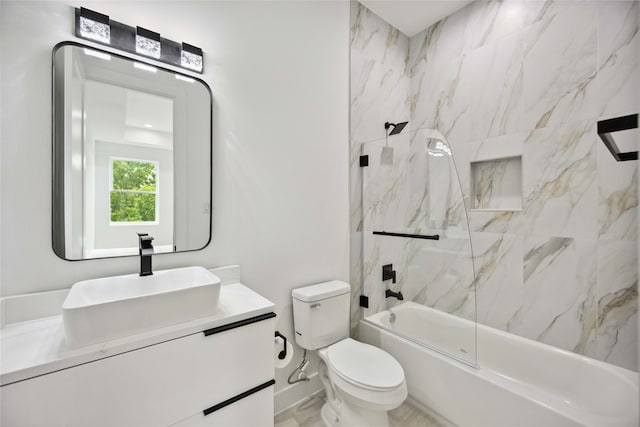 full bathroom featuring tiled shower / bath, vanity, and toilet