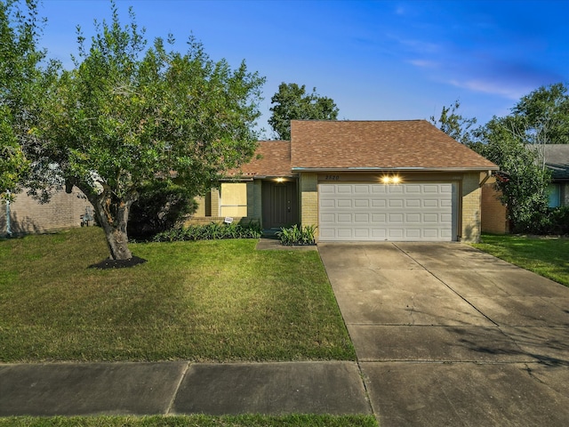 ranch-style house featuring a garage and a front lawn