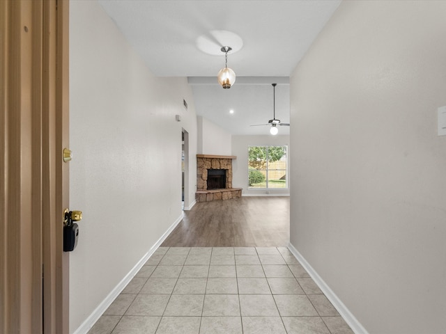 corridor with vaulted ceiling and light tile patterned floors