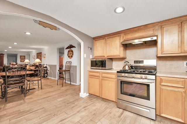 kitchen featuring ventilation hood, light hardwood / wood-style flooring, stainless steel appliances, and light brown cabinets