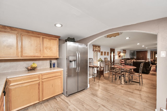 kitchen with light hardwood / wood-style floors, stainless steel fridge with ice dispenser, and light brown cabinets