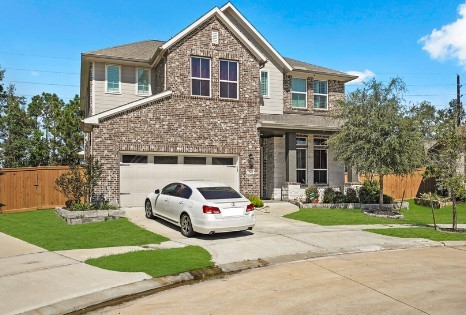 front facade with a garage and a front lawn