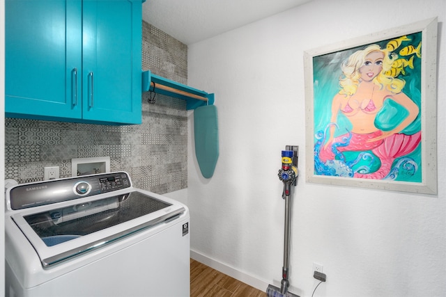 washroom featuring dark hardwood / wood-style floors, washer / clothes dryer, and cabinets