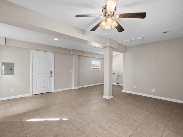 basement with a textured ceiling, electric panel, light tile patterned floors, and ceiling fan