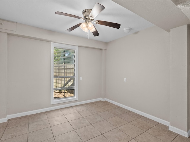 spare room with ceiling fan and light tile patterned floors