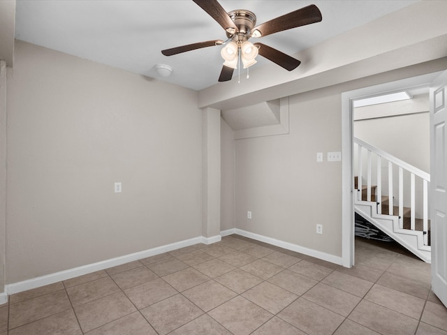 basement featuring light tile patterned floors and ceiling fan