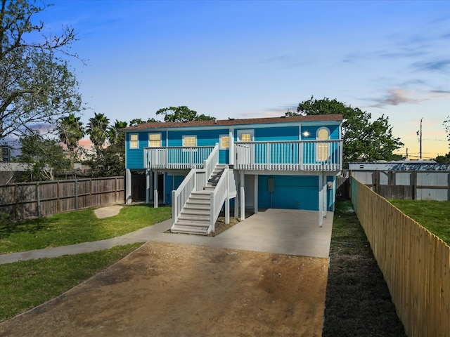 raised beach house featuring a lawn