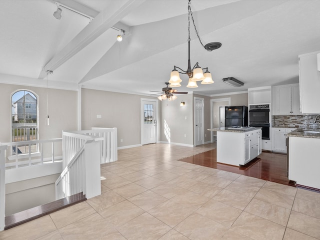 kitchen with vaulted ceiling with beams, white cabinets, light tile patterned flooring, track lighting, and a center island