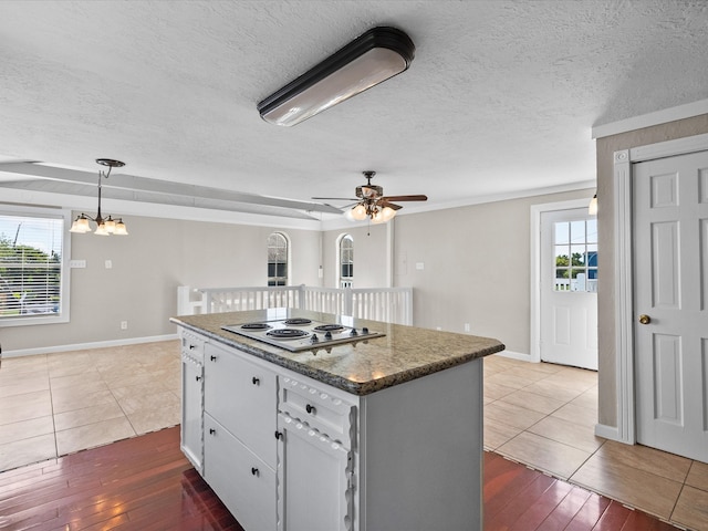 kitchen featuring white electric stovetop, plenty of natural light, dark wood-type flooring, and a kitchen island