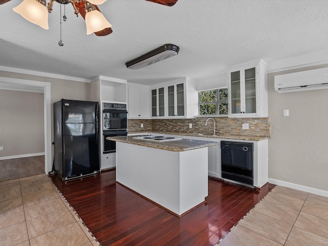 kitchen featuring dark hardwood / wood-style floors, black appliances, a kitchen island, and white cabinetry