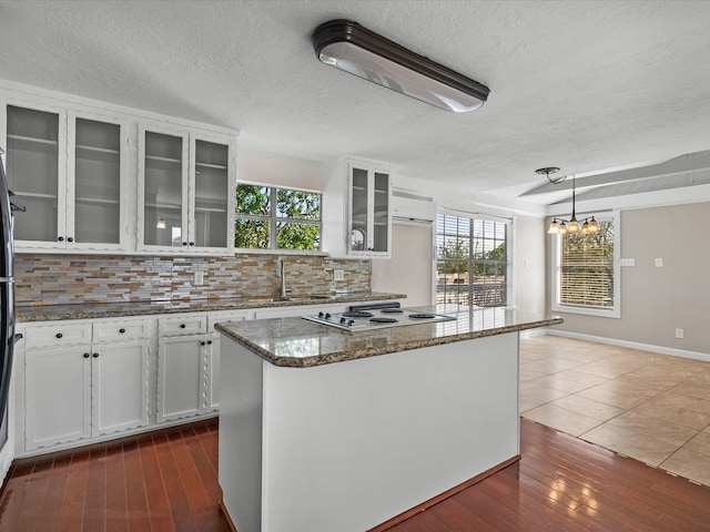 kitchen with hanging light fixtures, white cabinetry, white gas stovetop, and dark hardwood / wood-style flooring