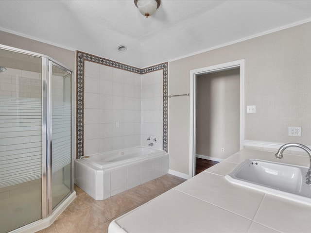 bathroom with shower with separate bathtub, sink, a textured ceiling, and tile patterned floors