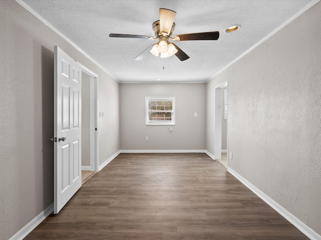 spare room featuring ceiling fan, ornamental molding, a textured ceiling, and dark hardwood / wood-style flooring