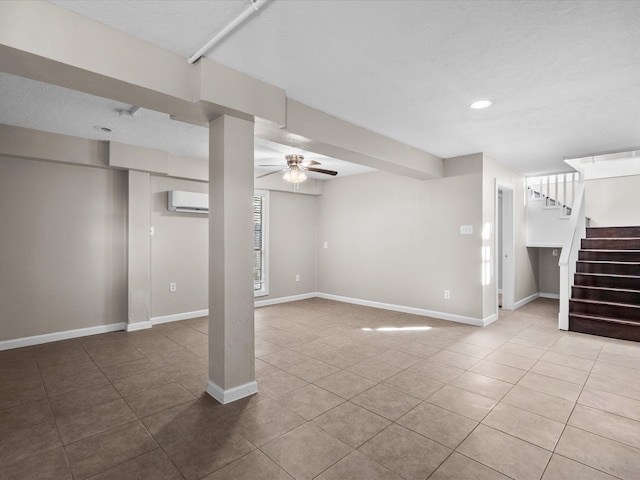 basement with ceiling fan, tile patterned flooring, and a wall mounted AC