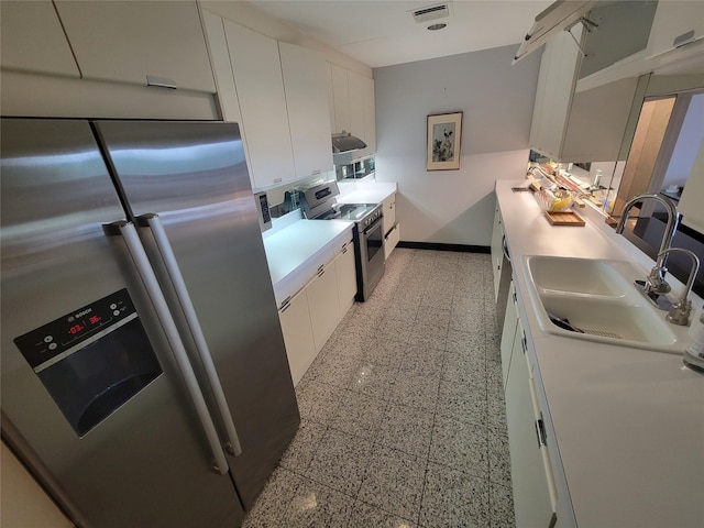 kitchen with appliances with stainless steel finishes, sink, and white cabinetry