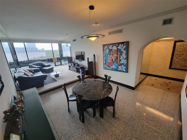 dining space featuring crown molding and floor to ceiling windows