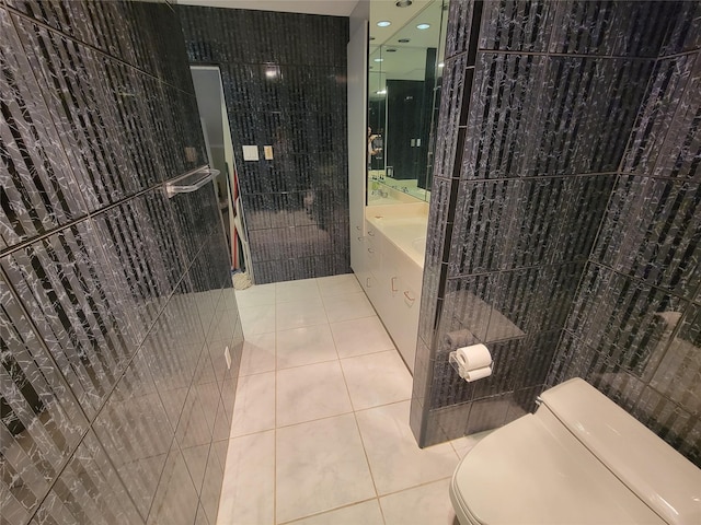 bathroom with tile walls, tile patterned floors, and toilet