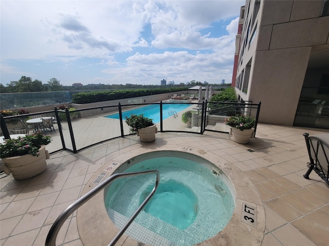 view of swimming pool featuring a patio and a hot tub