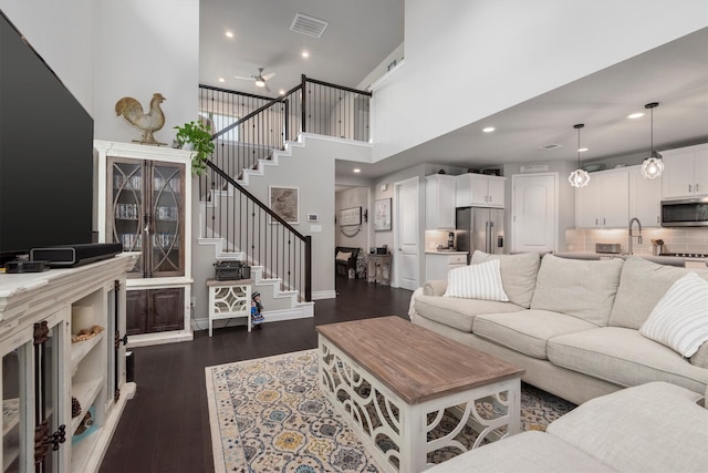 living room featuring a high ceiling and dark hardwood / wood-style flooring