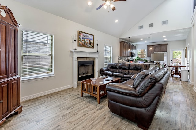 living room with light wood-type flooring, high vaulted ceiling, and ceiling fan