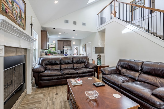 living room featuring light hardwood / wood-style floors and high vaulted ceiling