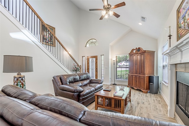 living room with high vaulted ceiling, light hardwood / wood-style flooring, and ceiling fan