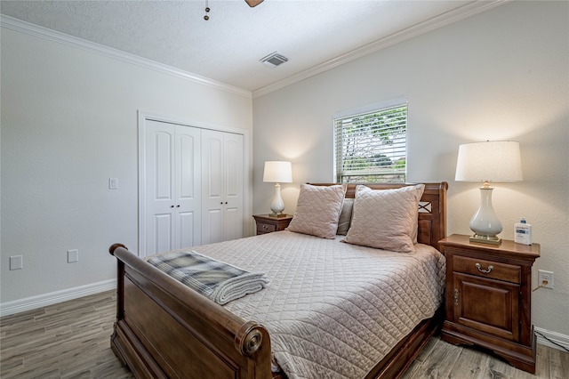 bedroom featuring a closet, crown molding, hardwood / wood-style flooring, and ceiling fan