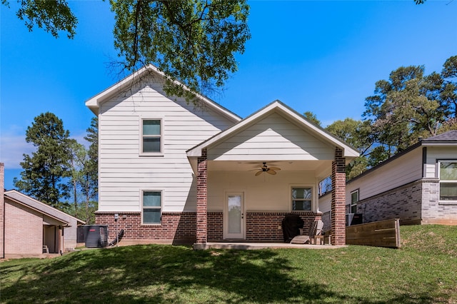 rear view of house with ceiling fan, a yard, and central air condition unit