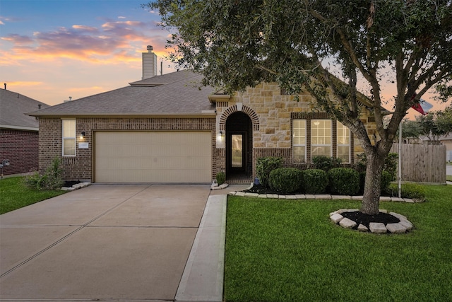 view of front of house featuring a garage and a lawn