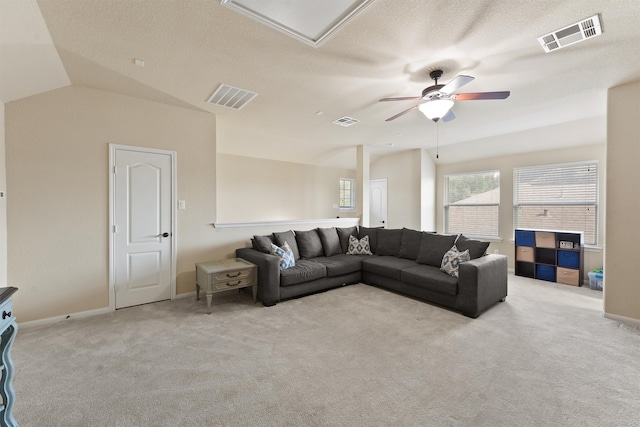 carpeted living room featuring ceiling fan, a textured ceiling, and lofted ceiling