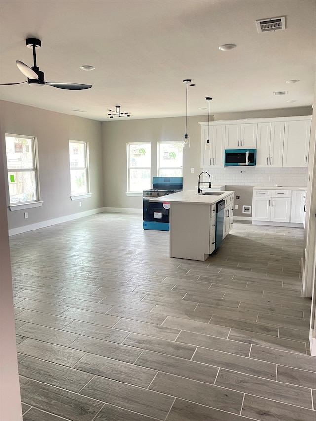 kitchen with white cabinets, appliances with stainless steel finishes, dark hardwood / wood-style floors, and a wealth of natural light