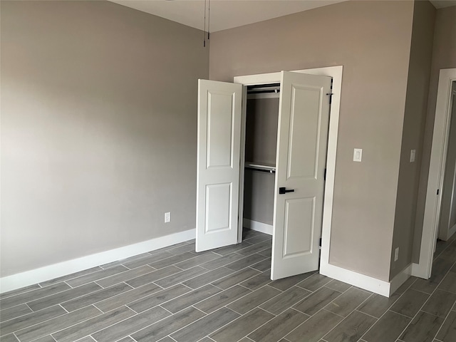 unfurnished bedroom featuring a closet and dark wood-type flooring