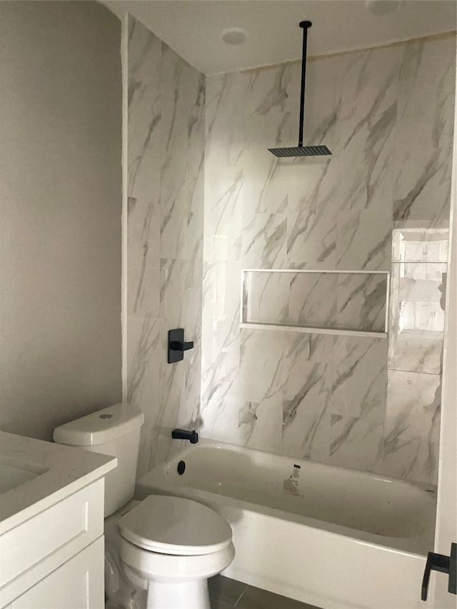 full bathroom featuring vanity, tiled shower / bath combo, and toilet