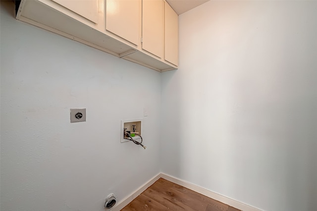 laundry room with hookup for a washing machine, electric dryer hookup, wood-type flooring, and cabinets