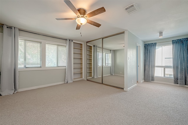 carpeted spare room with ceiling fan and a healthy amount of sunlight