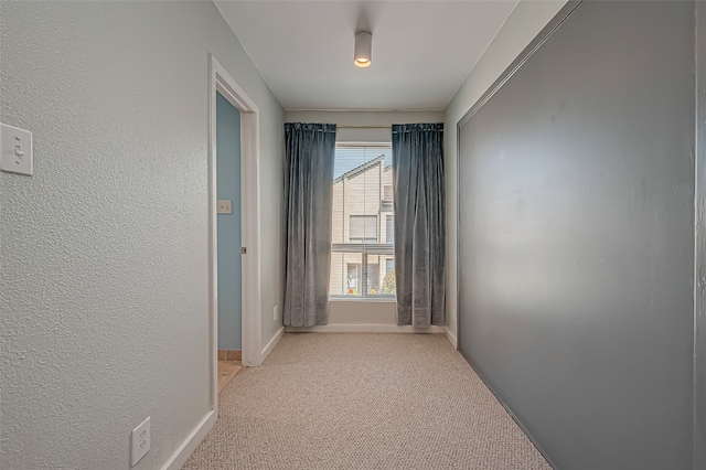 hallway featuring light colored carpet