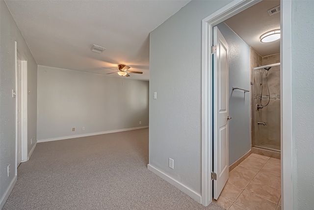 hallway featuring a textured ceiling and light tile patterned floors