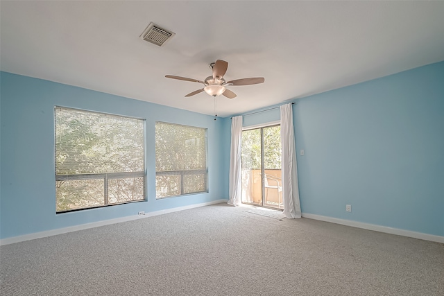 carpeted spare room featuring ceiling fan