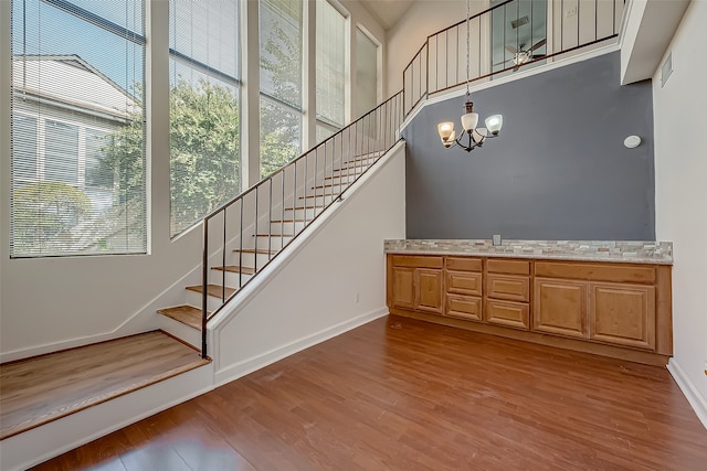 staircase featuring a notable chandelier and wood-type flooring