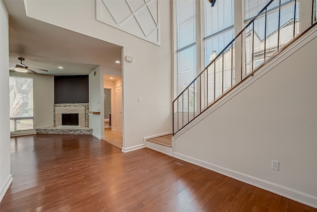 unfurnished living room featuring wood-type flooring, a fireplace, and ceiling fan