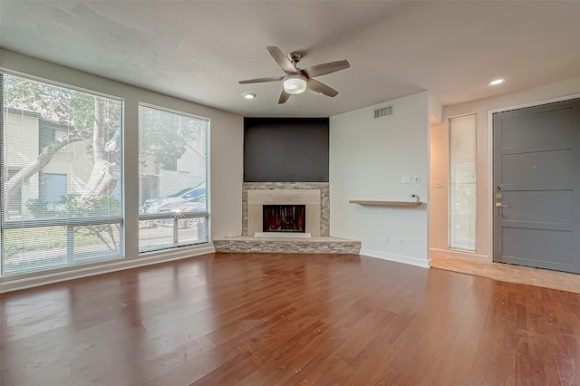 unfurnished living room featuring a fireplace, hardwood / wood-style flooring, and plenty of natural light