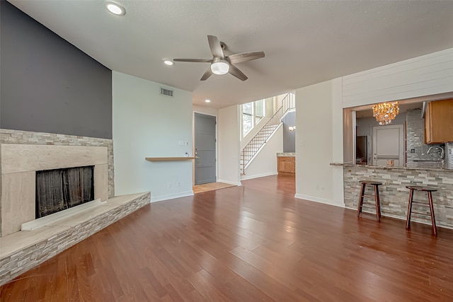 unfurnished living room with hardwood / wood-style floors and ceiling fan with notable chandelier