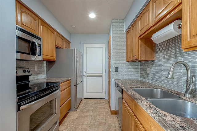 kitchen with sink, appliances with stainless steel finishes, decorative backsplash, and light tile patterned floors