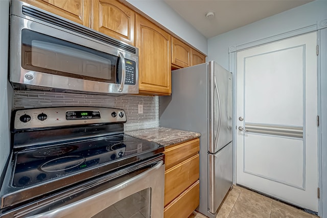 kitchen featuring appliances with stainless steel finishes, tasteful backsplash, and stone countertops