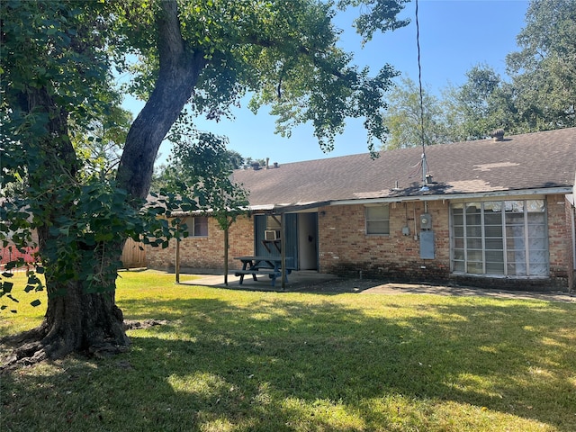 rear view of house featuring a lawn and a patio area