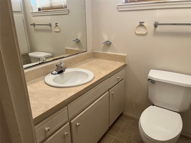 bathroom featuring vanity, tile patterned flooring, and toilet