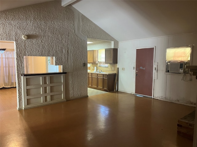 unfurnished living room with cooling unit, sink, beam ceiling, high vaulted ceiling, and a wealth of natural light