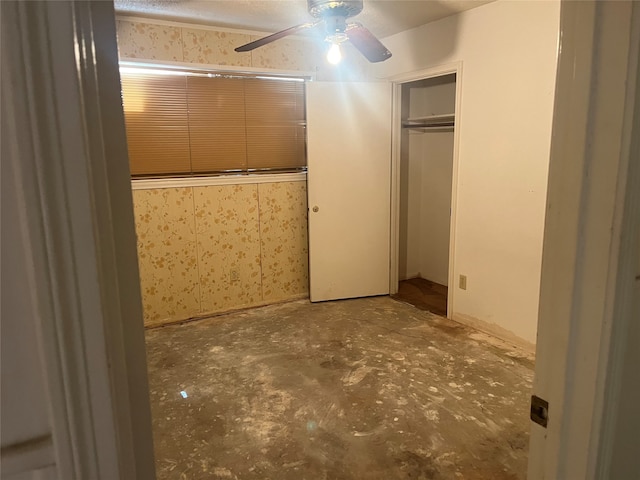 unfurnished bedroom featuring a closet, concrete flooring, and ceiling fan