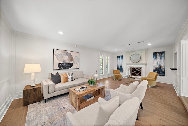 living room with crown molding and light hardwood / wood-style floors